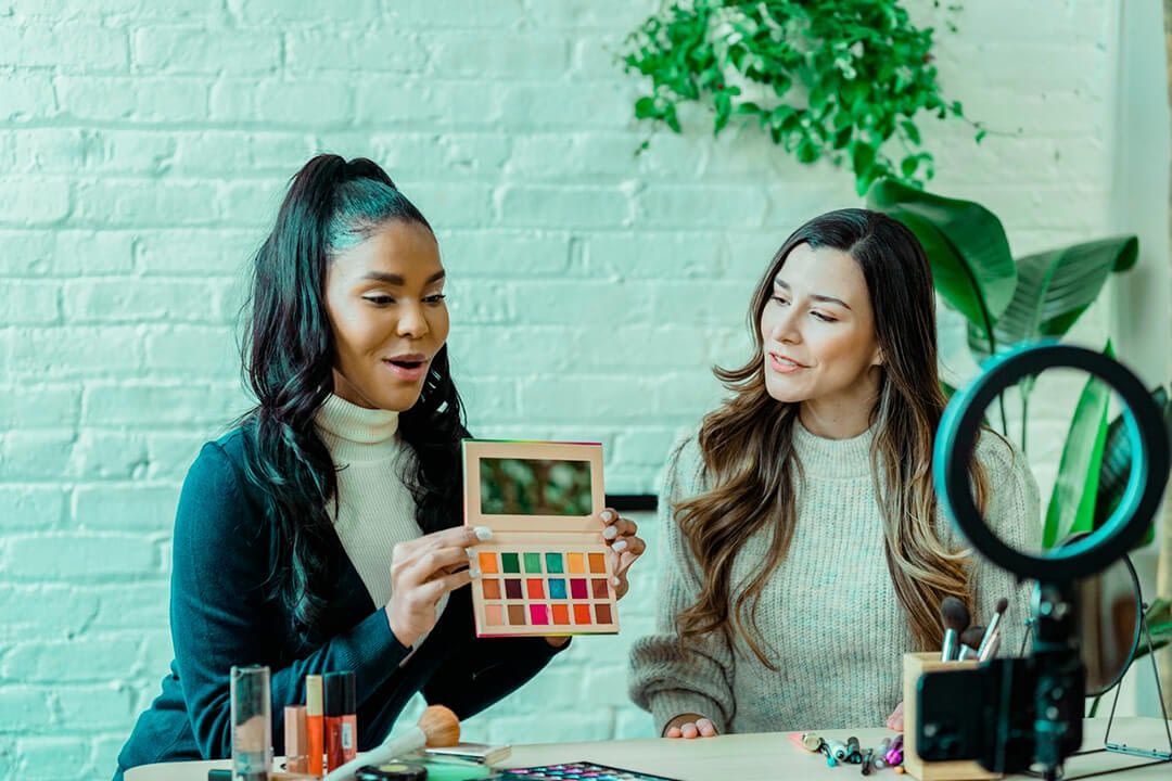 two female influencers vlogging makeup demo