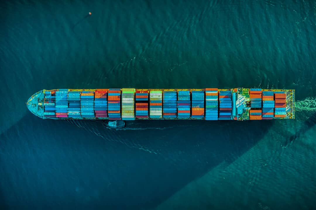 ship loaded with shipping containers travelling the sea