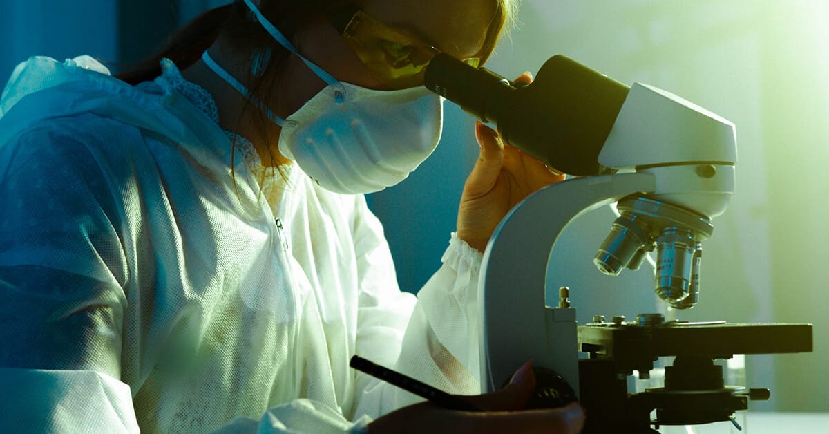 scientist looking through a microscope as clinical research featured image